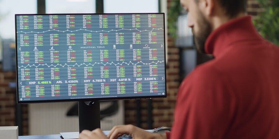 Young investor working on computer with real time stock charts Young investor working on computer with real time stock charts, following trade market sales trend. Financial analyst using forex exchange statistics to plan data analysis, index profit. Close up.